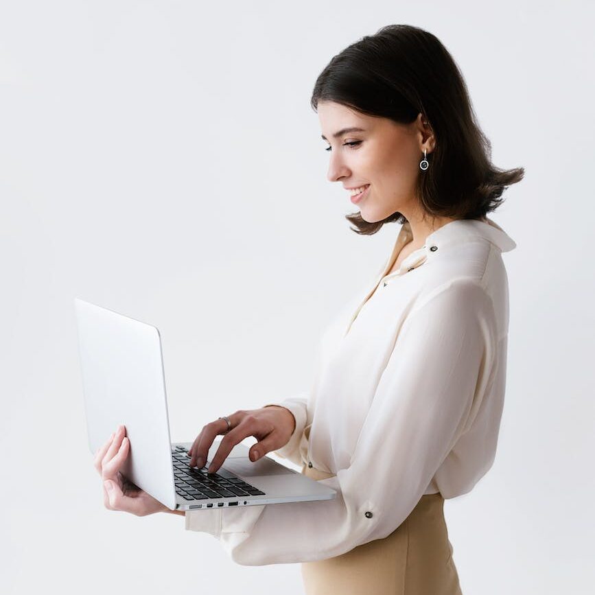 a woman typing on laptop while standing